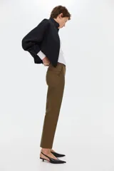 Pantalón cigarette color marrón, confeccionado en tejido elástico, con tiro estándar, bolsillos al bies y piernas ajustadas con raya marcada.