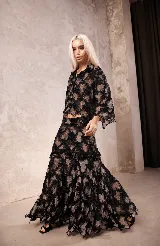Falda larga de encaje de terciopelo color negro, con diseño en capas y detalle de galón de piedras en la cadera.