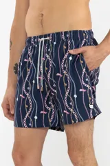 Short de baño azul marino con estampado de cadenas doradas, charms y libélulas en rosa.