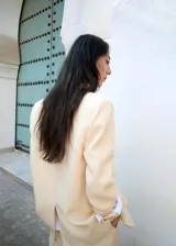 Blazer color beige confeccionado en mezcla de lino, viscosa y lyocell, de corte holgado con solapas de muesca, bolsillos con solapa en los laterales y cierre frontal de un botón.