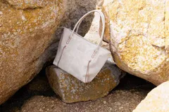 Cartera tote bag de cuero vacuno color negro, con detalles de trenzado lateral en contraste con flecos, asas largas de hombro y compartimento amplio con bolsillo interior.