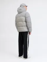 Campera puffer de corte regular, color gris, con capucha desmontable, cierre frontal con solapa, puños elásticos y diseño acolchado horizontal.