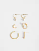 Set de aros dorados con strass rosados, con diferentes diseños: aros tipo argolla con dije colgante, aros tipo argolla con strass en la parte frontal y aros con forma de gota con strass en la parte frontal.