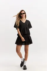 Blusa blanca de algodón con escote en V, mangas amplias y vuelo suave. Cuenta con un recorte en la cintura con frunce que aporta volumen y una caída fluida, además de una textura sutil con bordado inglés.