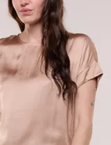 Blusa azul marino de silueta relajada confeccionada en satén, con escote redondo, hombros caídos y mangas cortas de corte japonés con puño doblado.