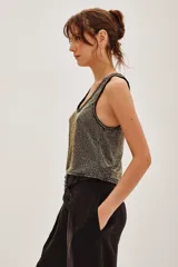 Musculosa de punto con acabado metalizado en tonos negro y dorado, con escote en V y bordes acanalados.