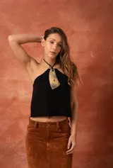 Top negro de cuero con cuello halter y aplique de guampa.