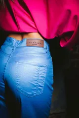 Pantalón jean de tiro alto color azul metálico, con bolsillos delanteros y traseros.