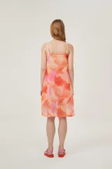 Musculosa con estampado abstracto en tonos naranja y rosa, con breteles finos y escote en V con lazo ajustable.