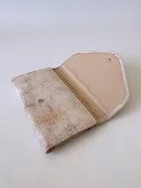 Billetera de cuero color crudo con textura, cierre con broche y monedero externo.