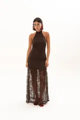 Vestido largo de encaje color chocolate, con escote halter y diseño ajustado en el torso que se abre en una falda con transparencia en el ruedo.