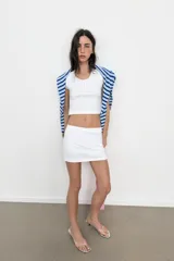 Sandalia tipo mule con tacón kitten, suela con acabado metalizado plateado, tira frontal transparente tipo vinilo con separación para el dedo y punta redonda.