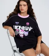 Remera de algodón negra con cuello redondo en color rosa, manga corta y diseño estilo racing. Presenta estampado frontal con personajes de Hello Kitty y Kuromi, junto con tipografía japonesa y detalles gráficos.
