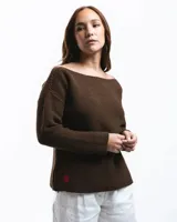 Buzo de lana merino con cuello bote y mangas largas. Presenta un detalle bordado a mano en color azul en la parte inferior.