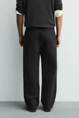 Pantalón de corte wide fit confeccionado en tejido con mezcla de lyocell. Presenta pliegues frontales dobles, bolsillos laterales y bolsillos traseros de vivo. Cierre frontal con cremallera y gancho metálico oculto.