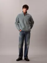 Buzo polar de Calvin Klein con cuello alto y cierre de media cremallera frontal. Presenta un diseño de manga larga con puños elásticos y un parche con el logo de la marca en el pecho.