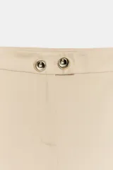 Pantalón negro de tiro medio con pierna ancha y cierre frontal de cremallera con dos botones dorados decorativos.