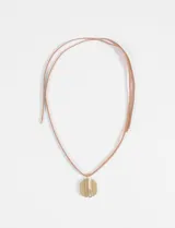 Collar de cordón fino en tono natural con un dije metálico circular de acabado brillante y diseño texturizado.