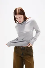 Polera de lyocell color negro, con cuello alto y ajuste al cuerpo, de manga larga.