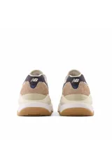 Championes urbanos New Balance modelo 57/40, con diseño de paneles en tonos beige, blanco y azul marino. Presentan una entresuela gruesa y suela de goma color caramelo.