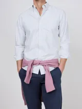 Camisa Oxford de corte regular fit, color blanco con finas rayas verticales, cuello buttondown y manga larga con puño simple. Cuenta con cierre frontal de botones y logo bordado en el pecho.