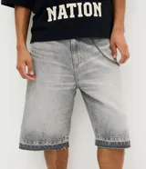 Bermuda de jean estilo baggy con corte recto y holgado, color gris lavado. Presenta detalles de costuras decorativas en el ruedo y diseño de cinco bolsillos.