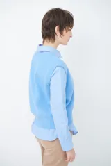 Chaleco de punto sin mangas, color azul, con cuello redondo y diseño de calce holgado.