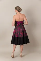 Vestido strapless negro con estampado de hojas fucsias y guarda calada negra en el bajo.