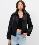 Campera de cuero sintético estilo trench, con cuello solapa, cierre frontal de botones y lazo ajustable en la cintura. Presenta detalles utilitarios en hombros y puños.