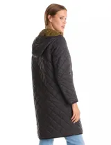 Campera reversible de corte largo con diseño capitoneado. Un lado presenta un tono verde oliva y el otro un tono negro, ambos con cierre frontal mediante botones a presión y bolsillos laterales.