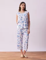 Conjunto de pijama marca René Rofé, compuesto por remera de mangas cortas con escote en V abotonado y pantalón capri con cintura elastizada. Diseño estampado con flores azules sobre fondo blanco.