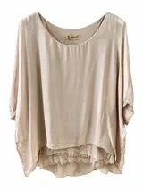 Blusa beige de corte holgado, con escote redondo, mangas cortas murciélago y dobladillo asimétrico con detalles de flecos.