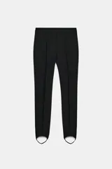 Pantalón negro de tiro alto con detalle de nervio en el delantero y bajo acabado en fuseau. Cierre frontal con cremallera, botón y ganchos metálicos.