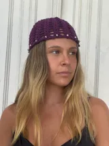Gorro de crochet color violeta con tachas plateadas alrededor del borde.