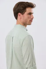 Camisa de lino y algodón color blanco, con cuello mao, manga larga y cierre frontal de botones. Presenta un pequeño logo bordado en el pecho.