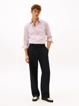 Camisa de manga larga Tommy Hilfiger de corte regular, confeccionada en popelín de algodón blanco con diseño de rayas verticales rojas. Cuenta con cuello clásico, cierre frontal de botones y el logo de la marca bordado en el pecho.