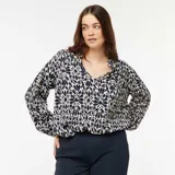 Blusa de manga larga con estampado floral en tonos azul marino y blanco, cuello en V y corte holgado.