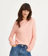 Blusa de punto color rosado con textura ondulada, cuello redondo y mangas largas con puños acanalados.