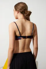 Top de bikini negro con estampado de jungla multicolor, corte recto y tirantes finos.