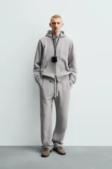 Pantalón jogger de corte regular fit y color negro, confeccionado en tejido compacto de algodón con interior de rizo. Cuenta con cintura elástica, bolsillos frontales y un bolsillo trasero de doble vivo.
