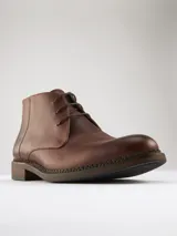 Botas de cuero marrón con cordones, caña baja y suela de goma.