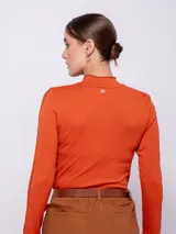 Top negro de manga larga con cuello alto y aberturas en los brazos.