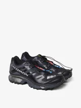 Championes Salomon modelo XT-4 OG de trail running, color negro con detalles en gris oscuro. Presentan un diseño técnico con sistema de cordones de ajuste rápido, estructura reforzada y suela con tecnología de amortiguación y tracción avanzada.
