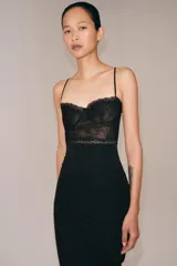 Vestido midi negro de tirantes finos, con corpiño estructurado y detalle de encaje negro en la parte superior.