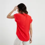 Blusa roja con textura de lunares, cuello redondo y mangas cortas con dobladillo.