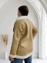 Tapado beige de ecocuero con interior de corderito blanco, con cuello solapa y bolsillos laterales.