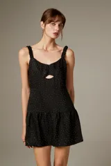 Vestido corto de poliéster color negro con estampado de lunares brillantes tipo strass, tirantes finos con volados, escote con abertura cut-out en el centro y falda con volado fruncido en el borde inferior.