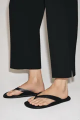 Pantalón de tiro medio con cintura con trabillas, detalle de raya planchada y bajo con aberturas laterales. Cierre frontal con cremallera, botón y ganchos metálicos.