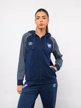 Campera deportiva con capucha y cierre frontal, de la marca Umbro para el Club Nacional de Football. Presenta un diseño en azul marino con mangas en tono gris jaspeado, detalles de vivos tricolores en los hombros y el escudo del club bordado en el pecho.