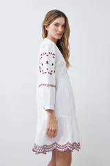 Vestido midi blanco con bordados de flores en el escote, mangas y ruedo.